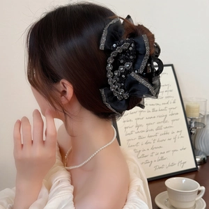 Pince à cheveux noeud noir élégante avec strass et paillettes sur le mannequin