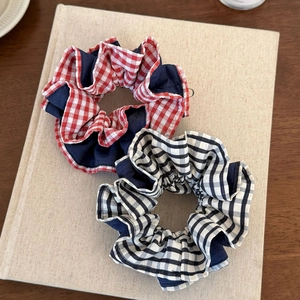 Set di elastici per capelli a quadri e blu su un libro per acconciature eleganti