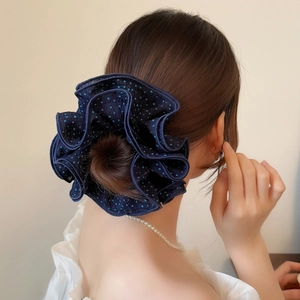 Navy blue polka dot hair scrunchie shown on a ponytail with premium textured fabric