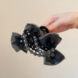 Détail de la pince à cheveux noeud noir avec cristaux et paillettes argentées