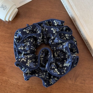 Macro detail of navy floral scrunchie showing four-layer edge stitching and fabric texture