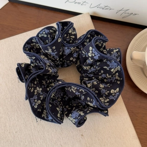 Detailed macro view of vintage navy blue floral scrunchie with four-layer edging and fabric