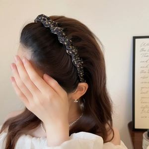 Elegant gold polka dot headband with twisted knot design and sparkling rhinestone accents