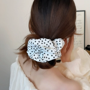 White floral fabric scrunchie with black patterns on ponytail for elegant hair styling