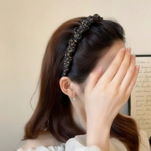 Elegant black and gold polka dot headband with knot design on model with long hair