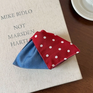 Detail of fabric hair claw clip featuring red polka dots and blue denim textures