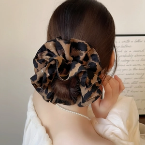 Elegant large leopard print scrunchie made of soft fabric on a model ponytail