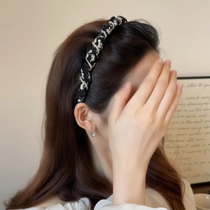 Serre-tête à motif floral avec chaîne de perles porté par un mannequin femme