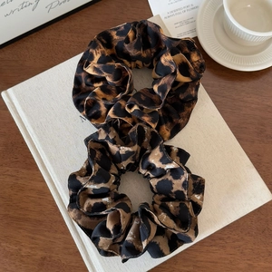 Double-layered leopard print scrunchies set on book, stylish fabric hair ties for women