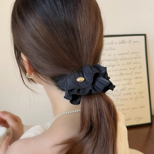 Elegant black pleated scrunchie with silk texture and a gold metal oval buckle detail