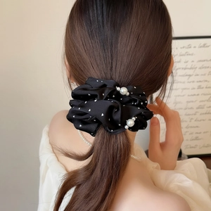 Chouchou élégant en satin noir à pois avec perles blanches sur une queue de cheval