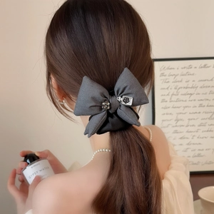 Elegant grey fabric bow hair scrunchie with rhinestone center and camellia pendant charm