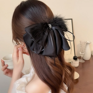 Elegant black satin bow hair claw with fluffy feathers and sparkling rhinestone center