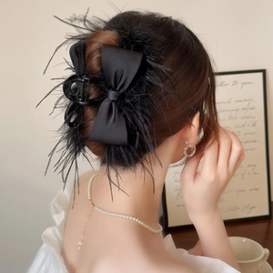 Elegant black feather hair claw clip with silk bow for women's high-volume hair styling