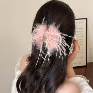 Détail de la pince à cheveux avec plumes roses et chaînes de strass scintillantes