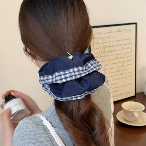 Blue vintage plaid scrunchie with golden heart pendant worn on model ponytail