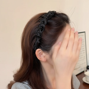 Padded black satin headband with twisted weave and small beads on female model