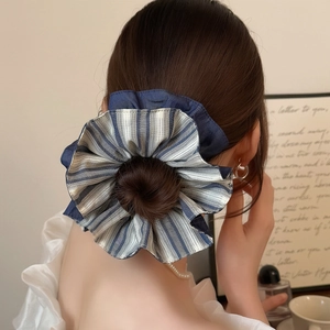 Blue and white striped layered scrunchie hair tie worn on a bun hairstyle for women