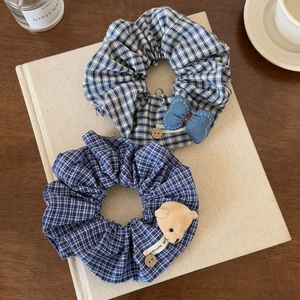 Lot de chouchous à carreaux bleus avec nœud en jean et ours en peluche sur un livre