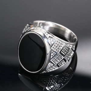 Macro view showing black oval gemstone and geometric textured band of silver ring