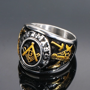Polished silver and gold freemason stainless steel ring with G compass logo on mirror background