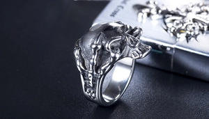 Macro side view of gothic punk ring featuring detailed skull and eagle claw textures