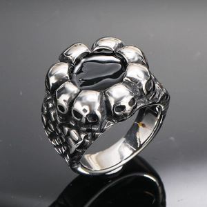 Anillo gótico de acero inoxidable con piedra negra y relieves de calaveras 3D