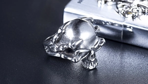 Macro shot of punk style steel skull ring on black leather with gothic lighter
