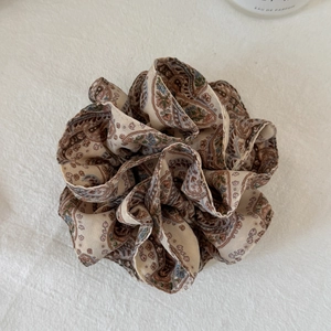 Detail view of large paisley print fabric scrunchie with soft pleated texture