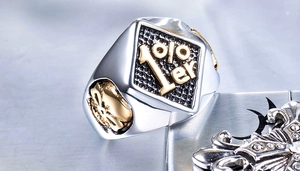 Makroaufnahme von Punk-Titanstahlring mit 1%er-Emblem und goldenem Totenkopf-Detail