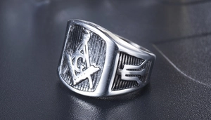 Detalle macro de anillo de sello masónico con escuadra, compás y letra G grabada