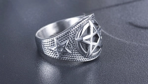 Macro detail of gothic pentagram ring showing vintage steel textures and engravings