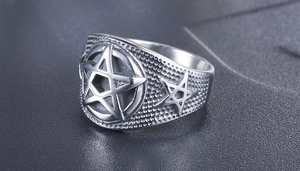 Macro side view of vintage punk pentagram ring with grainy metallic texture