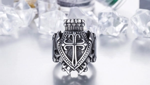 Close-up of vintage steel men's ring with crown cross emblem and shield design
