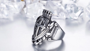 Macro shot of gothic stainless steel ring with shield cross and crown relief detail