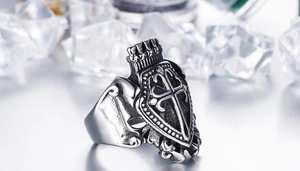 Close-up of vintage gothic stainless steel ring with crown cross and shield design
