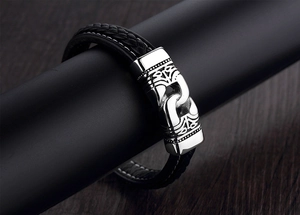 Close-up of men's braided leather bracelet with engraved silver stainless steel clasp