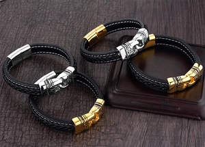 Close-up of four black braided leather bracelets with engraved vintage magnetic clasps