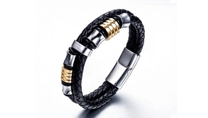 Detail of double-layer black braided leather bracelet with gold and silver metal accents