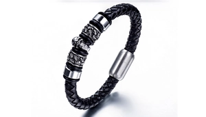 Détail d'un bracelet en cuir tressé noir pour homme avec un crâne en métal argenté punk