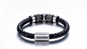 Vue détaillée du bracelet en cuir tressé avec des breloques en métal gravées de crâne
