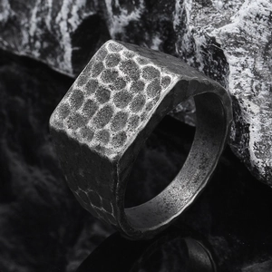 Detailaufnahme eines quadratischen Punk-Rings aus Titanstahl mit Hammerschlag-Textur
