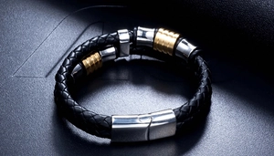 Close-up of black braided leather bracelet with gold and silver stainless steel rings