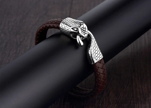 Close-up of brown braided leather bracelet with a detailed silver dragon head clasp