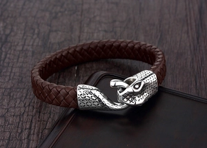 Macro shot of brown braided leather bracelet with silver dragon head metal clasp