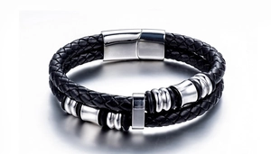 Close-up of black braided leather men's bracelet with silver metal rings and magnetic clasp