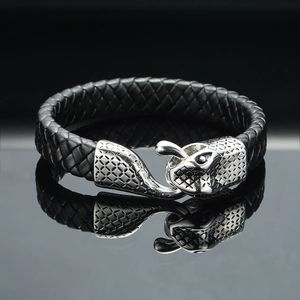 Macro shot of a braided black leather bracelet with a silver animal head metal clasp