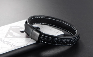 Detail of black woven leather bracelet featuring a sleek magnetic steel clasp closure