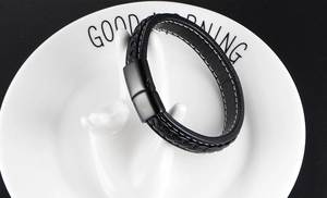 Close-up of woven black leather bracelet with matte black magnetic metal clasp