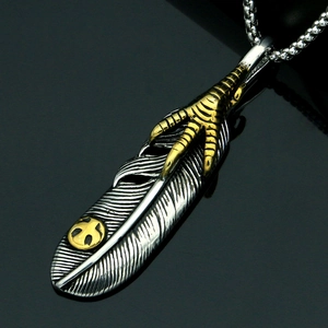 Retro titanium steel feather pendant with golden eagle claw on a mirror background